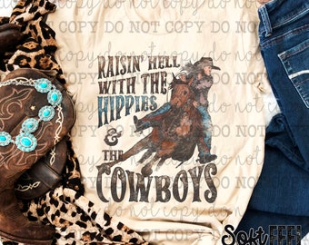 Op de afbeelding: Een beige t-shirt met de tekst "Raisin' Hell With The Hippies & The Cowboys" en een afbeelding van een persoon die op een paard rijdt. Het shirt ligt naast een spijkerbroek, een paar bruine cowboylaarzen en een luipaardprint sjaal.