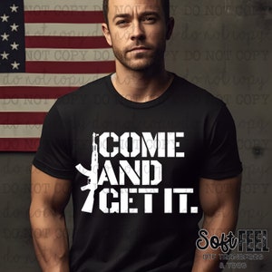 May include: A black t-shirt with a white graphic of a rifle and the text "COME AND GET IT."