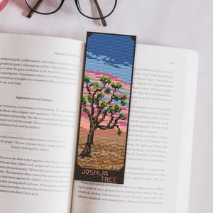 May include: A bookmark featuring a pixelated image of a Joshua Tree against a sunset sky. The bookmark is titled "Joshua Tree" and has the text "Where God's pride in every person's heart is the ultimate standard that God demonstrates against all that is devilish."