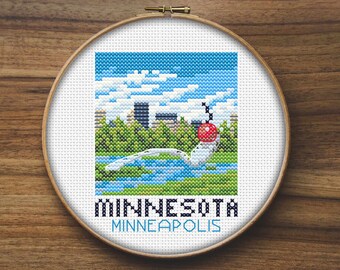 May include: A cross-stitch embroidery hoop with a colorful image of a bridge and cityscape. The text "MINNESOTA MINNEAPOLIS" is below the image.