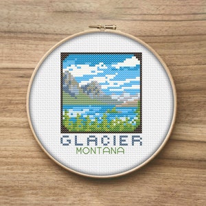Op de afbeelding: Borduurpatroon van een berglandschap met een meer en de tekst "GLACIER MONTANA".