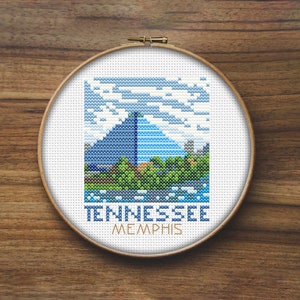 Op de afbeelding: Borduurring met een kleurrijk gepixelde afbeelding van een gebouw met een piramidevormig dak. De tekst "TENNESSEE MEMPHIS" staat onder de afbeelding.