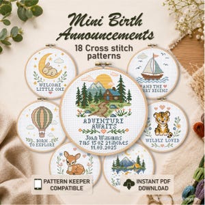 May include: A collection of seven circular embroidery hoops featuring cross stitch patterns with themes like a rabbit on a moon, a sailboat, a hot air balloon, a tiger, a deer, and a mountain cabin with the text Adventure Awaits, John Williams, 7lbs 15oz 21inches, 11.03.2025.