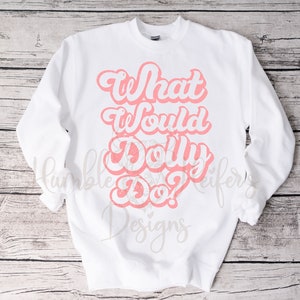 Pode incluir: Camisola branca com um gráfico rosa que diz "What Would Dolly Do?" em uma fonte retrô.