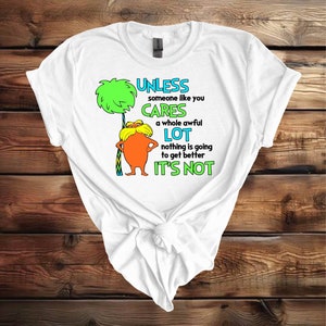 May include: White t-shirt with a green tree and a cartoon character with a mustache. The text on the shirt reads "Unless someone like you cares a whole awful lot nothing is going to get better it's not".