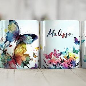 May include: White ceramic mug with a watercolor design of colorful butterflies and flowers. The mug has the name "Melissa" written on it.