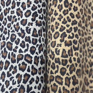 Pelle di mucca con stampa leopardata. Pelle di vitello pieno fiore. Bianco e beige per artigianato.