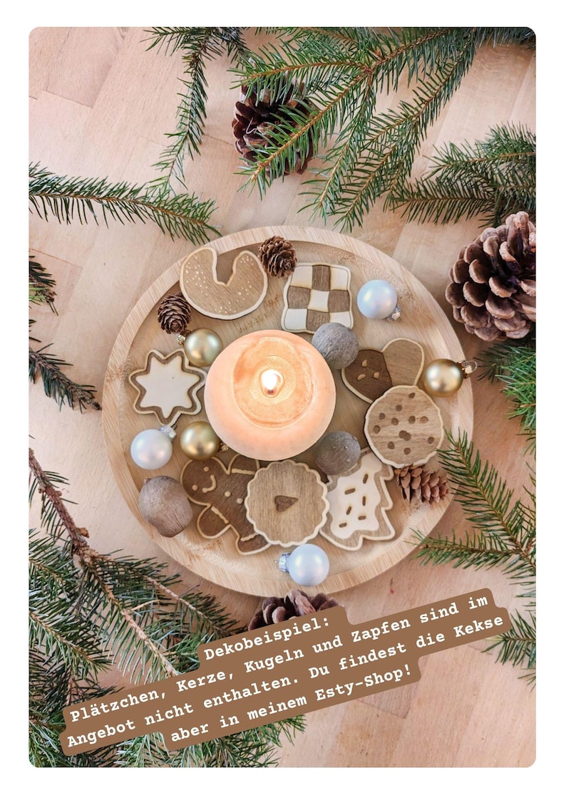 May include: A wooden tray featuring a lit candle, gingerbread biscuits, baubles, and pine cones. The biscuits are in diverse shapes, including stars and gingerbread men. Green pine branches surround the tray, creating a festive holiday display.