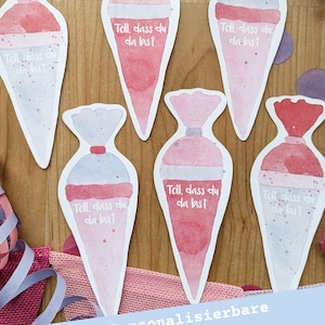Puede incluir: Etiquetas de regalo de acuarela en tonos rosa y rojo, con forma de conos de helado. Cada etiqueta tiene el texto "Toll, dass du da bist" y está dispuesta sobre una superficie de madera con cintas decorativas.