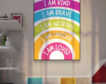 May include: A framed poster featuring a rainbow design with the words "I AM KIND, I AM BRAVE, I AM WORTHY, I AM UNIQUE, I AM LOVED" in white text. The poster is hung on a white wall above a set of shelves.