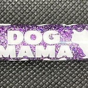 Puede incluir: Bolígrafo de purpurina morado con siluetas blancas de perros y el texto "DOG MAMA" en el cuerpo.