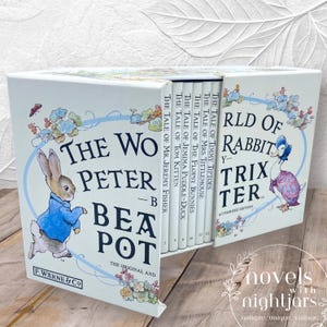 May include: A boxed set of children's books featuring illustrations of rabbits and other animals. The set includes titles like "The Tale of Peter Rabbit" and "The Tale of Mrs. Tittlemouse." The books are in a white box with the title "The World of Peter Rabbit."