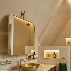 May include: A luxurious bathroom with a gold-toned sink, faucet, and mirror. The vanity is dark wood with gold accents, and the countertop is marble. A green towel hangs on a gold ring, and the walls are a neutral color.