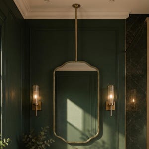 May include: A bathroom vanity featuring a white marble countertop with a round marble vessel sink and a gold faucet. Above sits a rectangular mirror with rounded corners suspended by a gold rod, flanked by two vertical glass wall sconces.