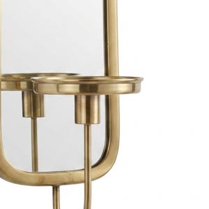 Puede incluir: Aplique de pared dorado con espejo y candelero. El espejo es rectangular con bordes redondeados. El candelero es circular y la base es curva. El dise&ntilde;o es simple y elegante.