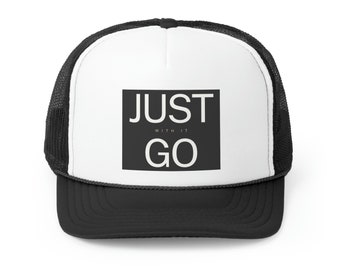 Op de afbeelding: Een zwart-witte truckercap met een zwart vierkant patch waarop in witte tekst "JUST WITH IT GO" staat.