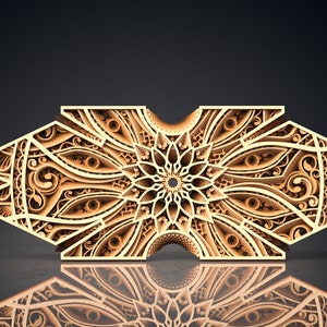 Könnte beinhalten: Eine dekorative Holz-Wandverkleidung mit einem komplizierten, symmetrischen Design. Die Verkleidung ist aus hellbraunem Holz gefertigt und weist ein sich wiederholendes Muster aus floralen Motiven auf. Die Verkleidung ist vor einem schwarzen Hintergrund platziert.