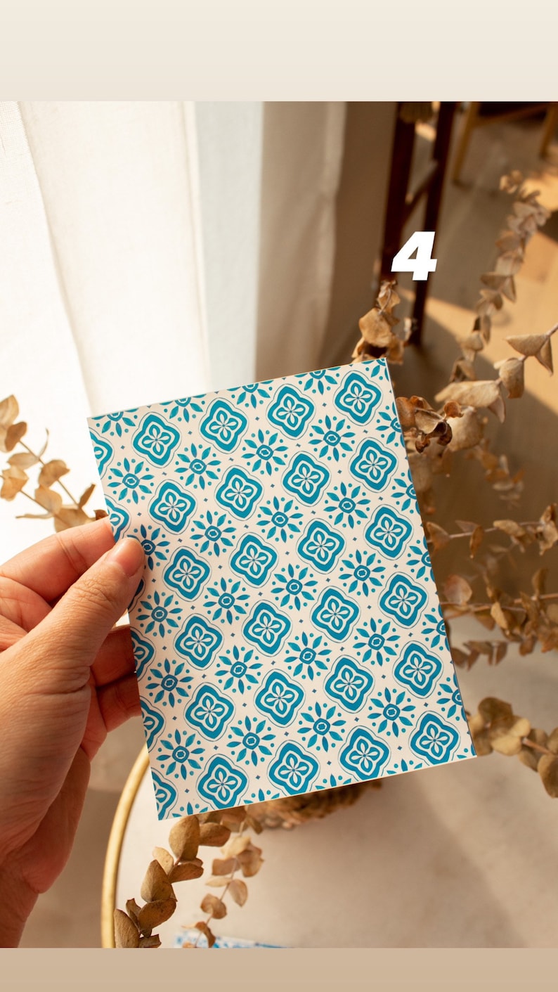 May include: A white card with a blue and white geometric pattern. The card is being held by a hand.