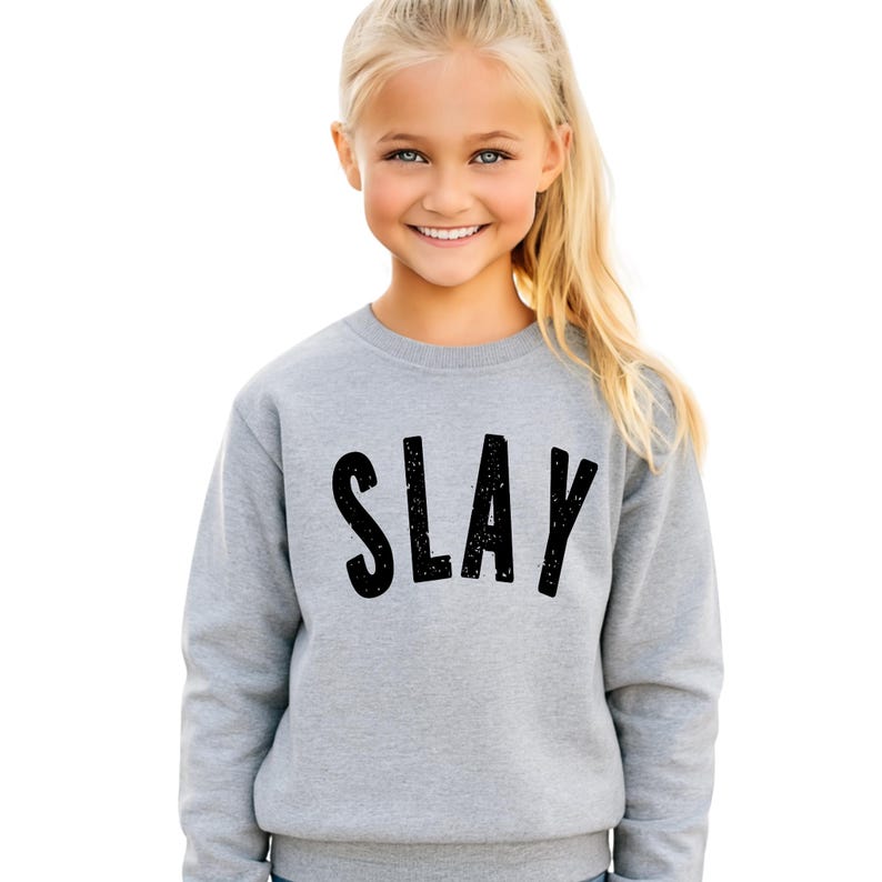 Light gray youth sweatshirt with black distressed SLAY graphic, kids unisex fleece pullover for girls and teens, trendy minimalist design mockup for children’s fashion.