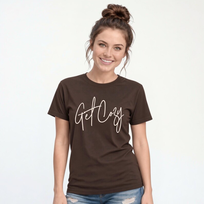 Woman wearing a brown Get Cozy T-shirt with white script and jeans for a casual fall outfit.