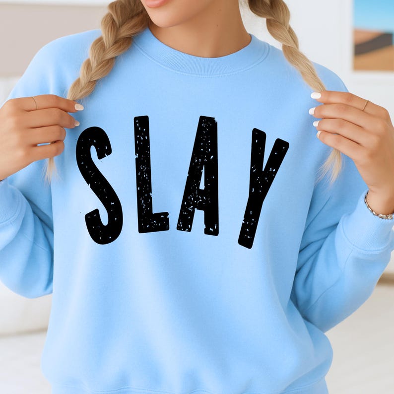 Light blue girls sweatshirt with black SLAY lettering, cozy cute unisex youth crewneck, trendy children’s fashion mockup with distressed bold text.