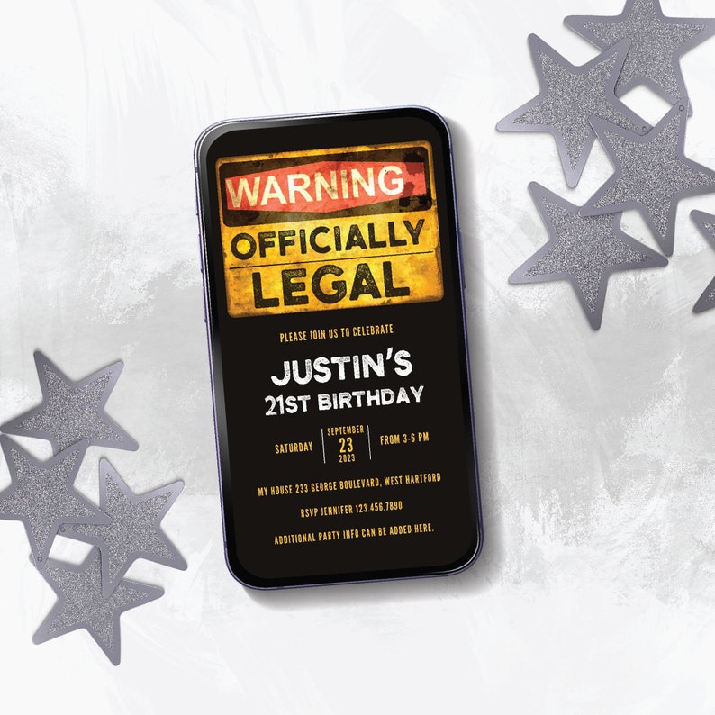 May include: A black smartphone with a 21st birthday party invitation on the screen. The invitation has a warning sign with the text "WARNING OFFICIALLY LEGAL" in yellow and red. The text "JUSTIN'S 21ST BIRTHDAY" is in gold. The invitation also includes the date, time, and location of the party.