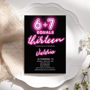 以下が含まれることがあります： ネオンピンクの文字が入った黒い招待状。カードには「6+7 EQUALS thirteen」と書かれており、ビクトリアの13歳の誕生日を祝うようゲストを招待しています。日付、時間、場所、RSVP情報が含まれています。