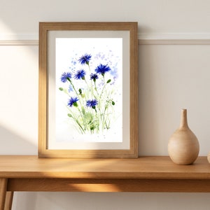 May include: A framed watercolor painting of blue wildflowers with green stems and leaves on a white background.