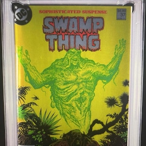 May include: A graded comic book featuring "Swamp Thing" #37. The cover art showcases a green Swamp Thing figure against a yellow background, with the title in red. The comic is encased in a protective holder.