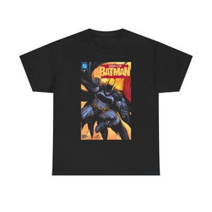 May include: Black t-shirt featuring a comic book cover with Batman in action. The cover art has a yellow and red background with the word "ABSOLUTE BATMAN" in large letters. The superhero is depicted in gray and black.