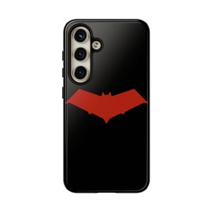 May include: Black phone case with a red bat logo. The case has a triple camera lens on the back.