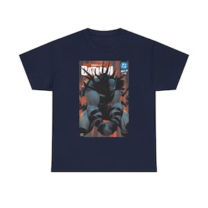 Puede incluir: Camiseta azul marino con un diseño de portada de cómic de Batman. El gráfico muestra a Batman en una pose oscura, con la palabra "Batman" y otro texto. La camiseta tiene un cuello redondo clásico.