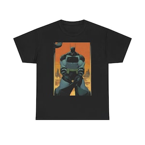 May include: Black t-shirt featuring a comic book illustration of Batman. The artwork depicts Batman in a powerful stance, with a cityscape backdrop in shades of orange and yellow. The superhero is in a dark gray and black suit.