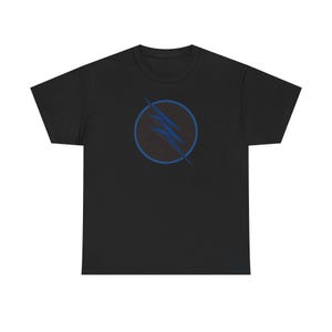 Puede incluir: Camiseta negra con un diseño circular azul y negro con tres rayos. El gráfico está centrado en la parte delantera. La camiseta está hecha de un material suave.