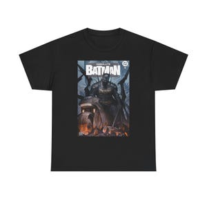 May include: Black t-shirt featuring a comic book cover with the text "ABSOLUTE BATMAN." The graphic depicts Batman on a motorcycle with a dark, detailed illustration. The shirt is a classic crew neck style.