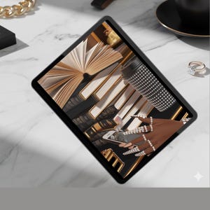 Può includere: Un tablet digitale mostra un'immagine di libri, gioielli e una tazza di caffè. Una catena d'oro, un orologio e un anello sono sulla superficie di marmo. Il tablet mostra una mano con unghie lunghe e anelli.