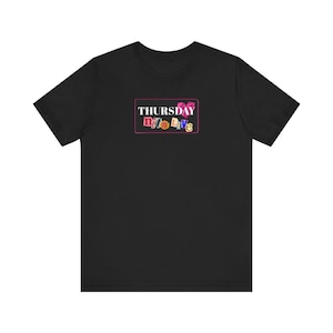 May include: Black t-shirt with a rectangular graphic on the front. The graphic features the word "THURSDAY" above the words "Nyte Live" in colorful, blocky letters, all within a pink border.