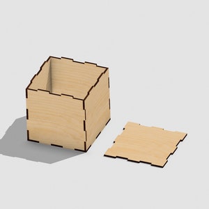 Pode incluir: Uma caixa de madeira com uma tampa, ambas de madeira clara com uma mancha marrom. A caixa está aberta e a tampa está ao lado.