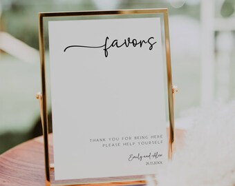 May include: A gold-framed sign with the word "favors" written in cursive. The sign also includes the text "Thank you for being here, please help yourself, Emily and Alex, 26.11.20XX".