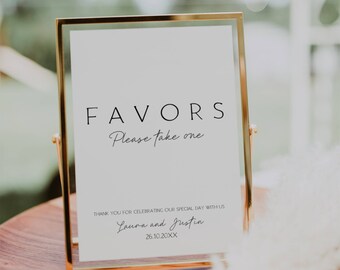 May include: A gold-framed sign with the text "FAVORS Please take one" and a thank you message from Laura and Justin for celebrating their wedding on 26.10.20XX.