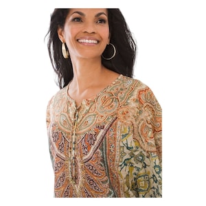 Könnte beinhalten: Ein beige-braunes Oberteil mit Paisley-Muster in Grün, das vorne mit Knöpfen geschlossen wird. Das Oberteil hat eine lockere Passform und einen runden Ausschnitt.