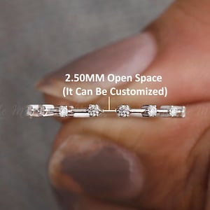 Puede incluir: Una delicada banda de plata con pequeños diamantes engastados en fila. La banda tiene un espacio abierto de 2,50 mm, que se puede personalizar. El texto "2,50 MM Open Space (It Can Be Customized)" está escrito sobre el anillo.