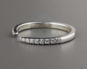 May include: A thin silver band with a row of small diamonds set in a curved shape.