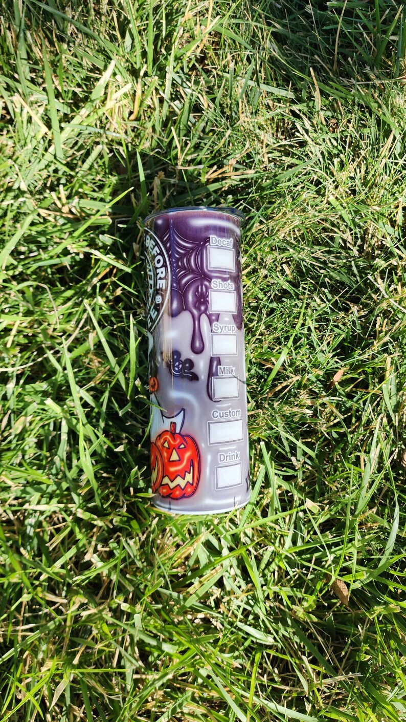 May include: A purple and black stainless steel tumbler with a Halloween-themed design. The tumbler has a white label with the words "Decaf", "Shots", "Syrup", "Milk", "Custom", and "Drink" printed on it.