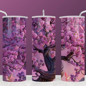 May include: A set of three stainless steel tumblers with lids and straws. Each tumbler features a vibrant design of a flowering cherry blossom tree with pink blossoms against a soft purple and pink background. The tree's dark, textured trunk adds contrast.