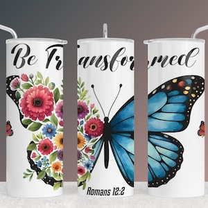 Pode incluir: Um copo branco com uma borboleta azul e um design floral. O copo tem o texto "Be Transformed" e "Romanos 12:2".