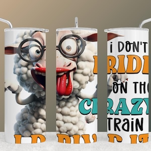 May include: A white tumbler with a cartoon sheep wearing glasses and sticking out its tongue. The tumbler has the text "I don't ride on the crazy train, I drive it" in orange, teal, and black.