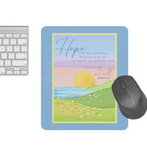 May include: A silver keyboard, a black wireless mouse, and a blue mousepad with a pastel landscape design. The mousepad features the text "Hope is the thing with feathers...and never stops at all."