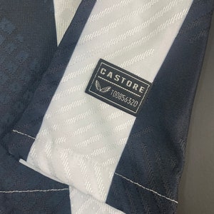 May include: Black and white striped fabric with a black label that says "CASTORE" and "100856320".