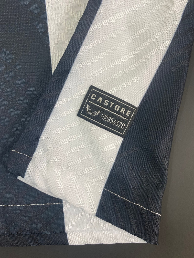 May include: Black and white striped fabric with a black label that says "CASTORE" and "100856320".